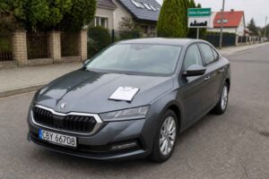 Szara Škoda Superb zaparkowana przy ulicy Solca Kujawskiego, z kartką na masce