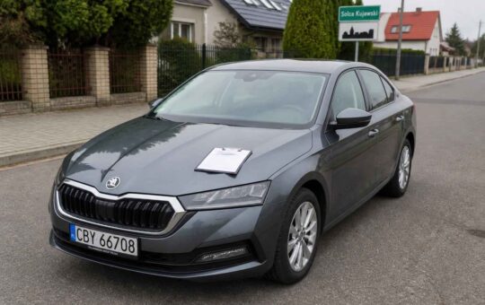 Szara Škoda Superb zaparkowana przy ulicy Solca Kujawskiego, z kartką na masce