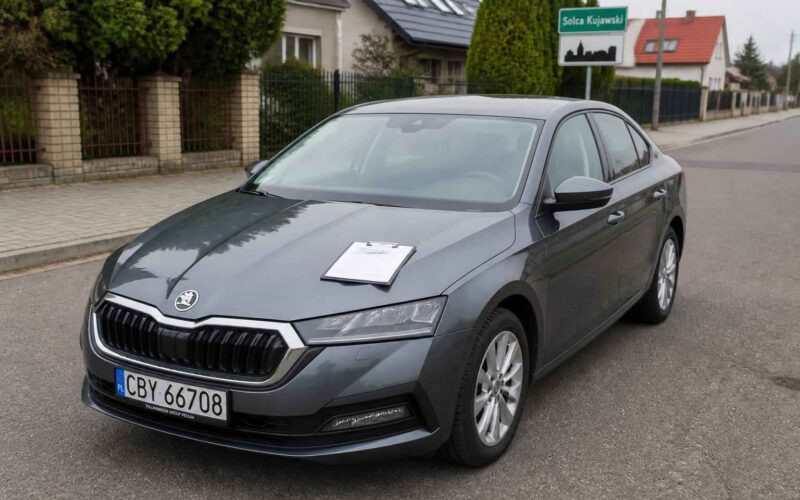 Szara Škoda Superb zaparkowana przy ulicy Solca Kujawskiego, z kartką na masce